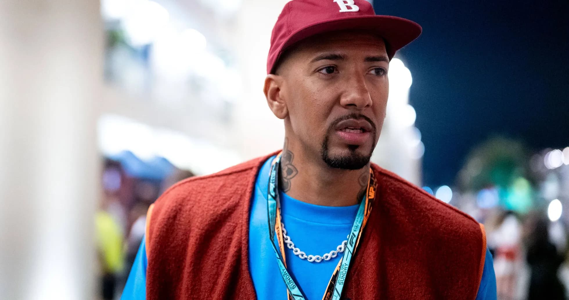 Hombre con gorra roja y chaqueta en evento nocturno