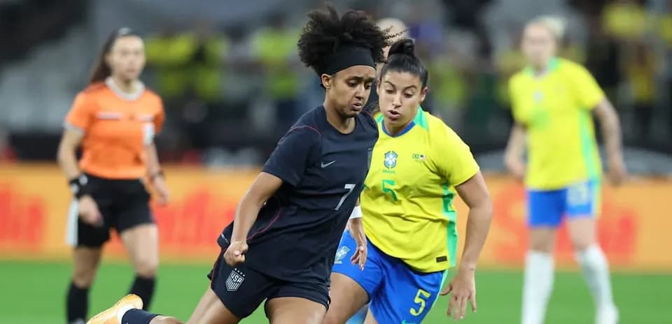 Jugadora de Estados Unidos driblando a jugadora de Brasil