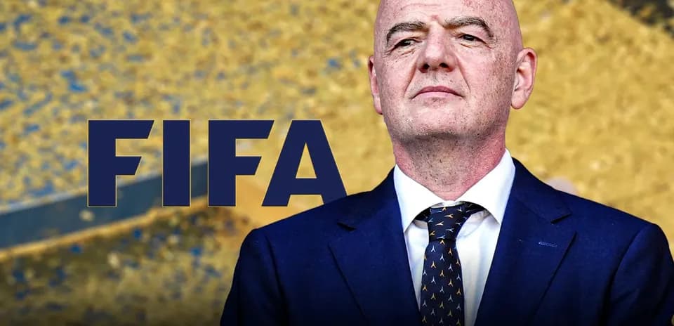 Persona en traje frente a fondo dorado con FIFA