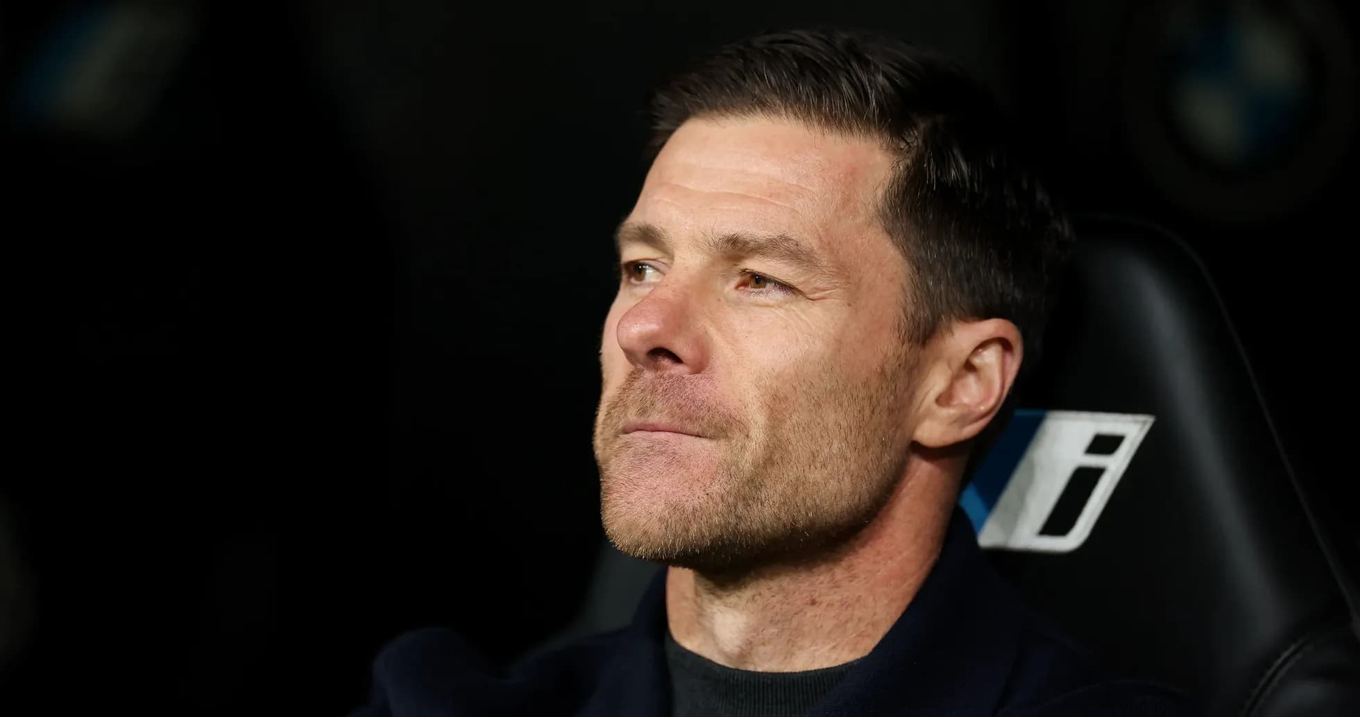 Entrenador observando desde el banquillo durante partido