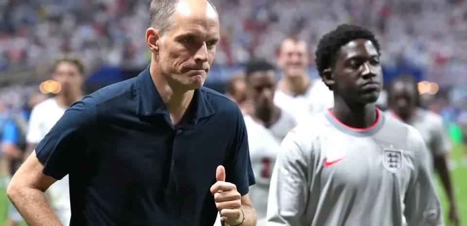 Entrenador y jugador saliendo del campo tras el partido