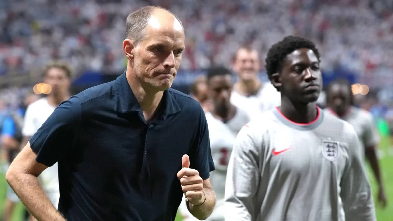 Entrenador y jugador saliendo del campo tras el partido