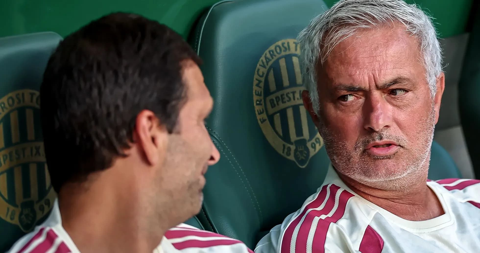 Entrenador conversando con jugador en el banquillo