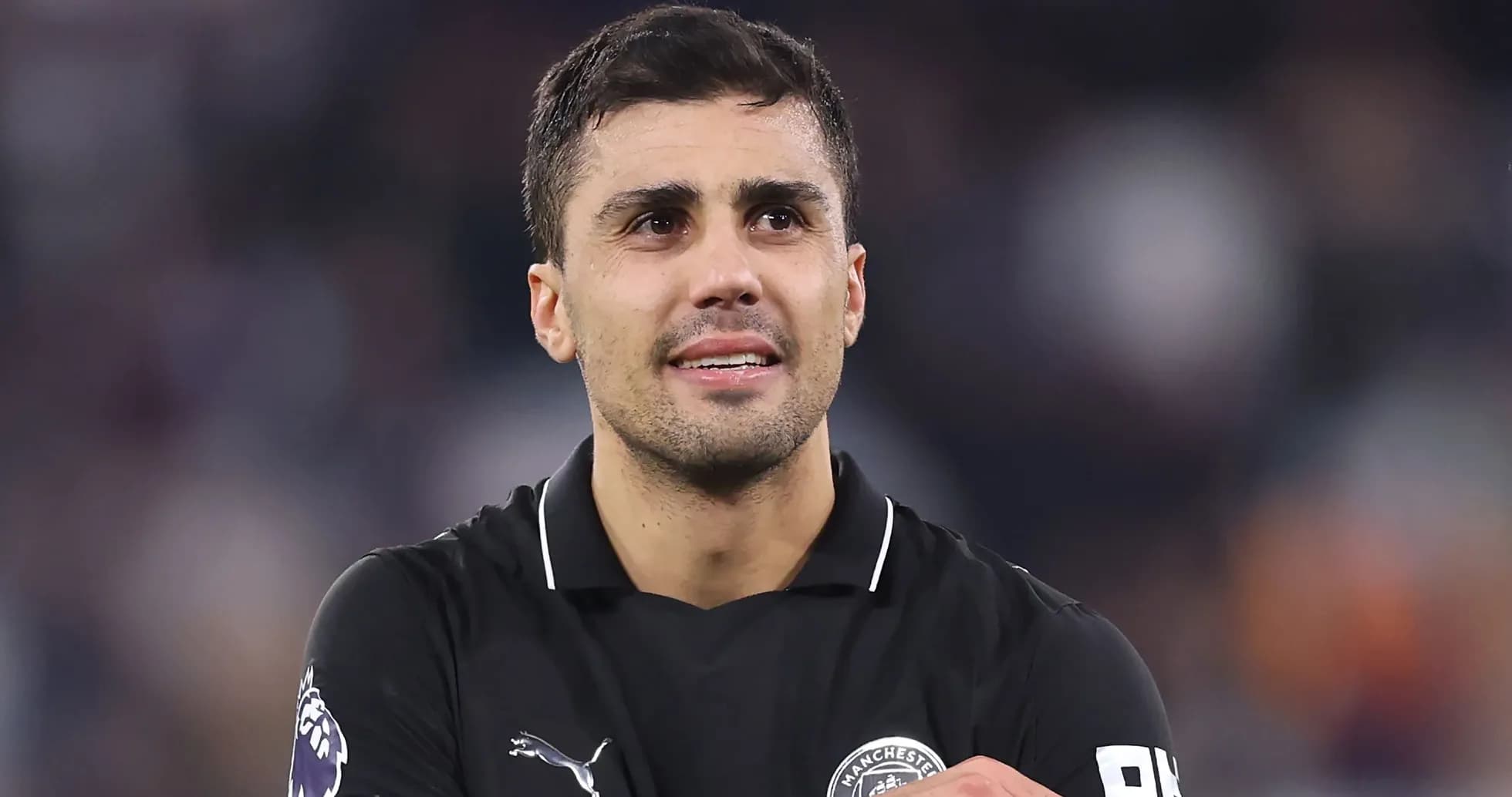 Jugador de fútbol en camiseta negra sonriendo