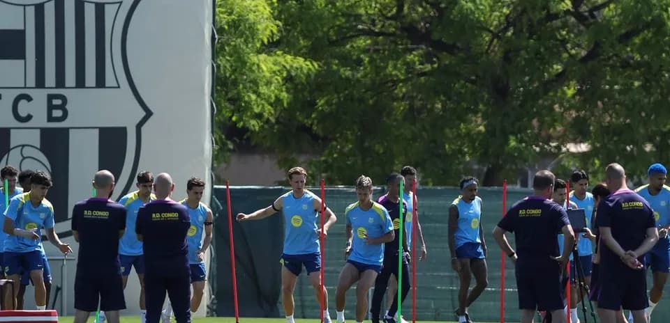 Equipo entrenando en campo con conos y vallas