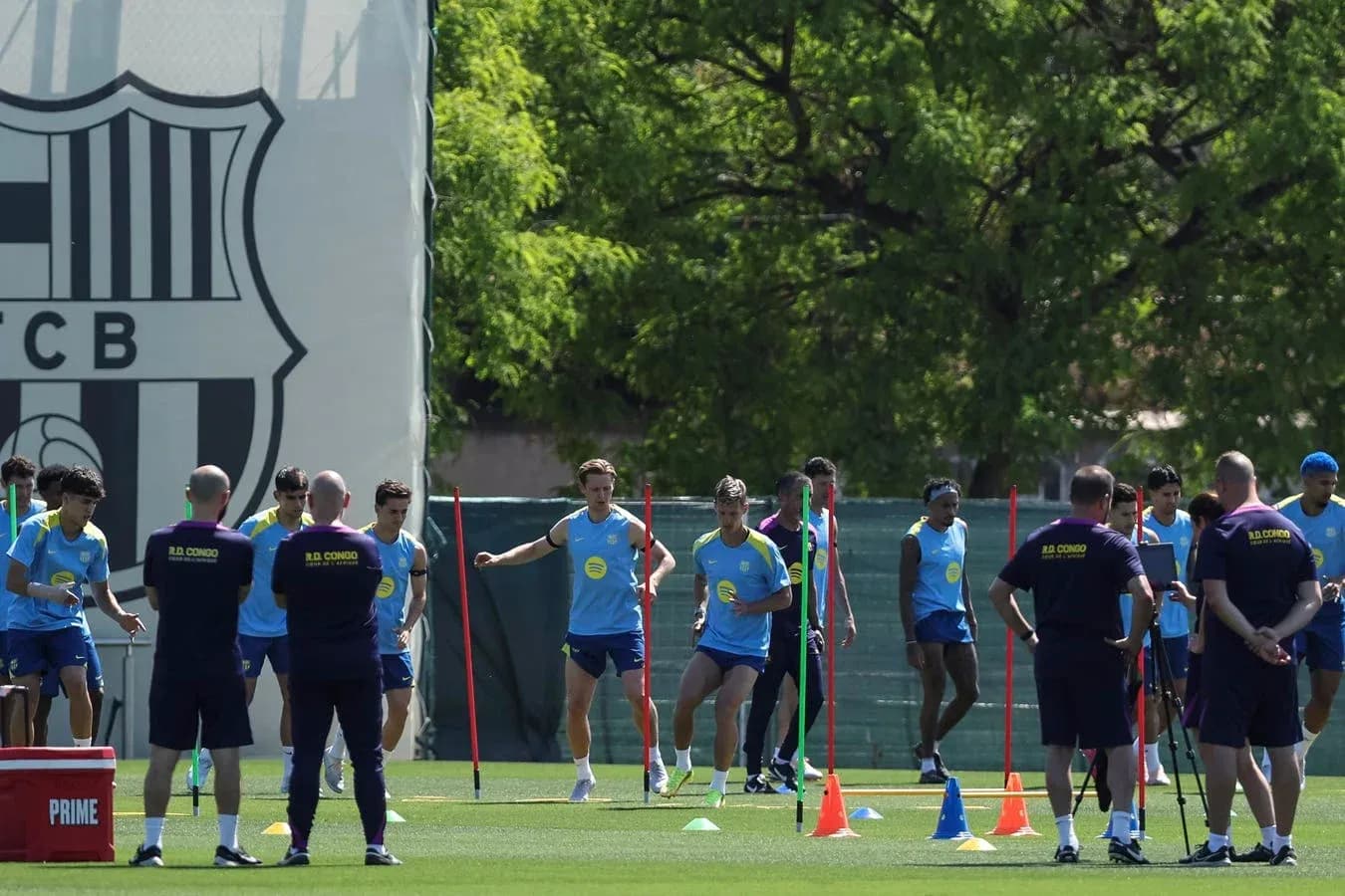 Equipo entrenando en campo con conos y vallas