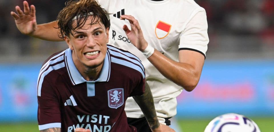 Jugador de Aston Villa siendo agarrado por oponente