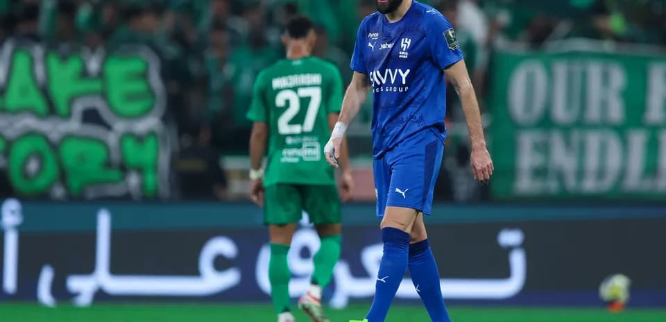 Jugador en uniforme azul camina por el campo