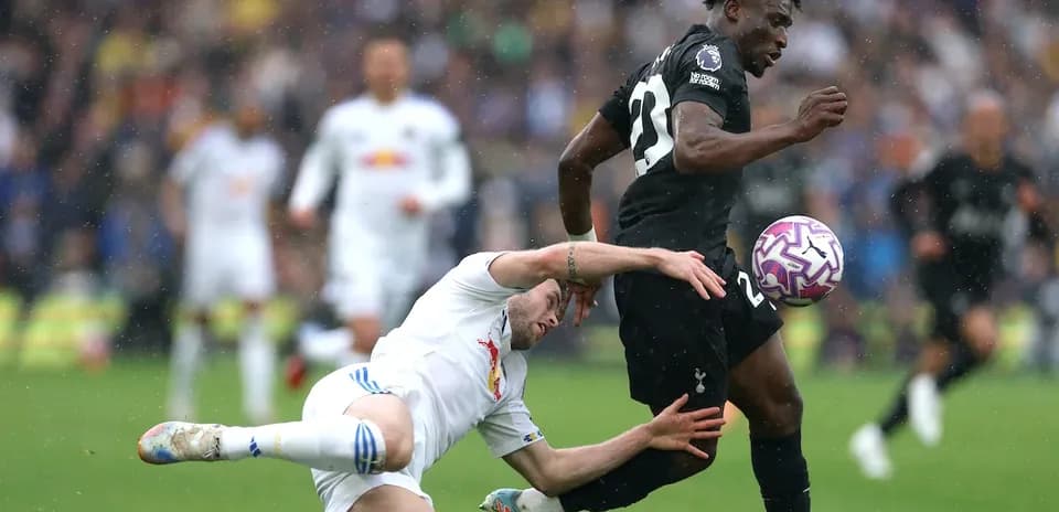 Jugador de Tottenham avanzando mientras otro cae al suelo