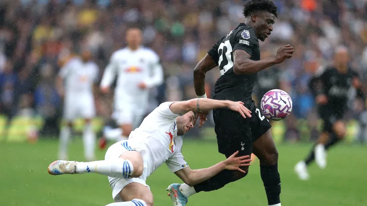 Jugador de Tottenham avanzando mientras otro cae al suelo