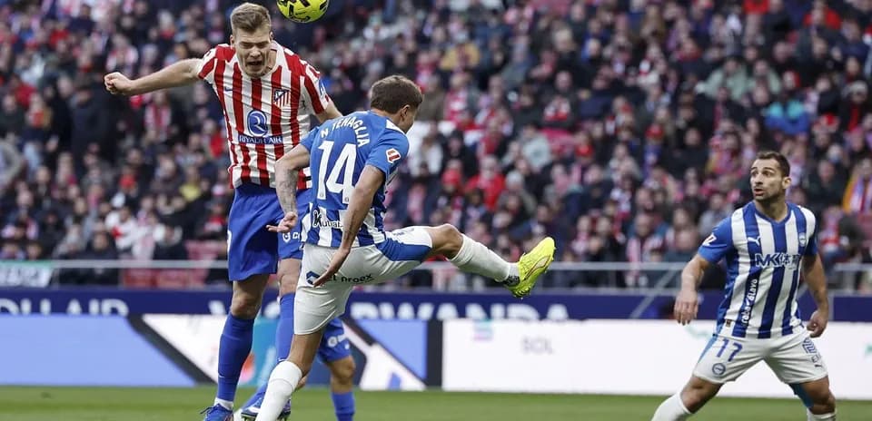 Jugador de Alavés desafiando a un jugador del Atlético