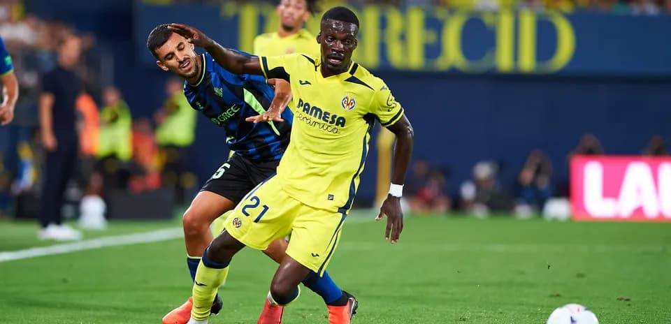 Jugador de Villarreal driblando mientras es marcado