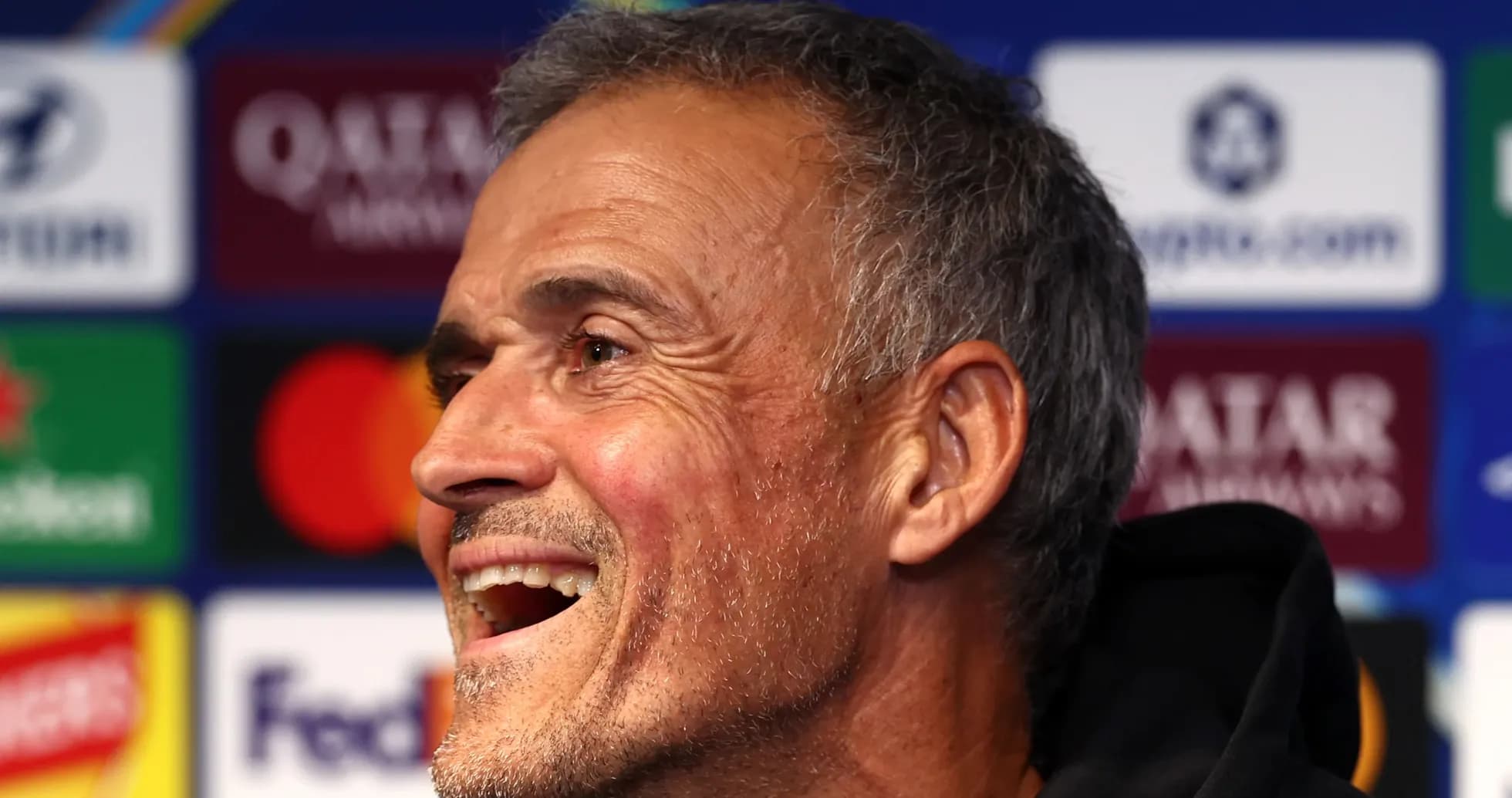 Entrenador sonriendo durante una rueda de prensa