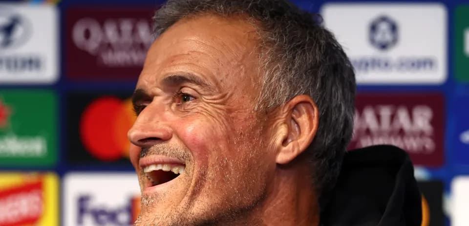 Entrenador sonriendo durante una rueda de prensa