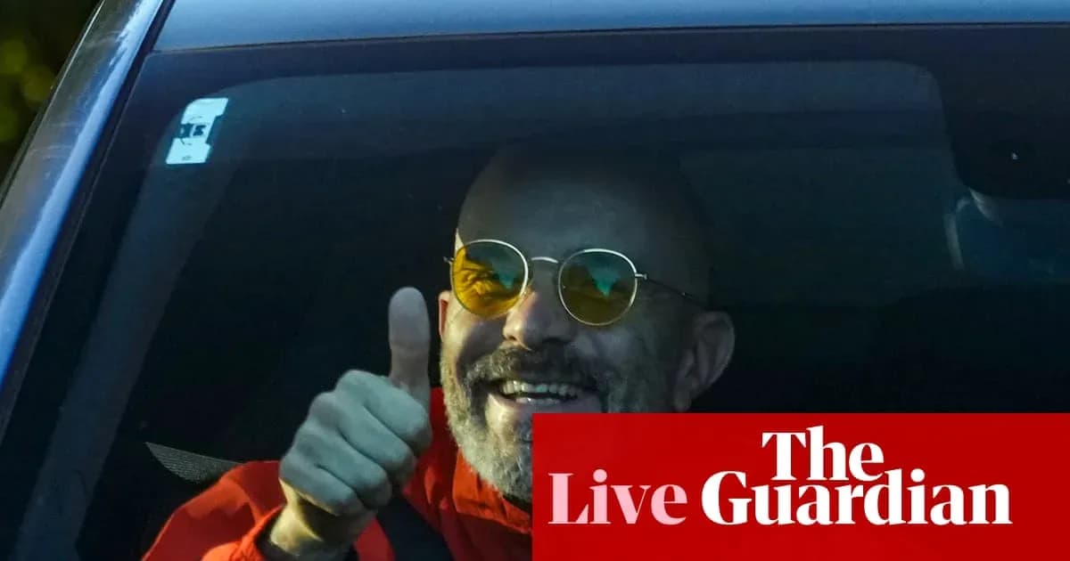 Hombre sonriendo y haciendo un pulgar hacia arriba desde un coche