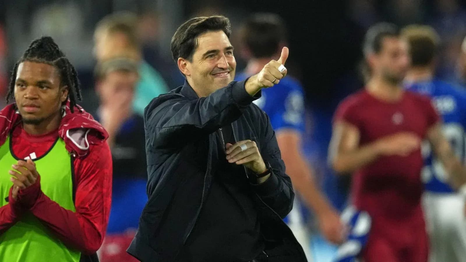 Entrenador sonriendo y haciendo gesto de pulgar arriba