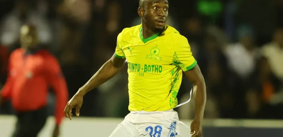 Jugador de fútbol en uniforme amarillo corriendo en el campo