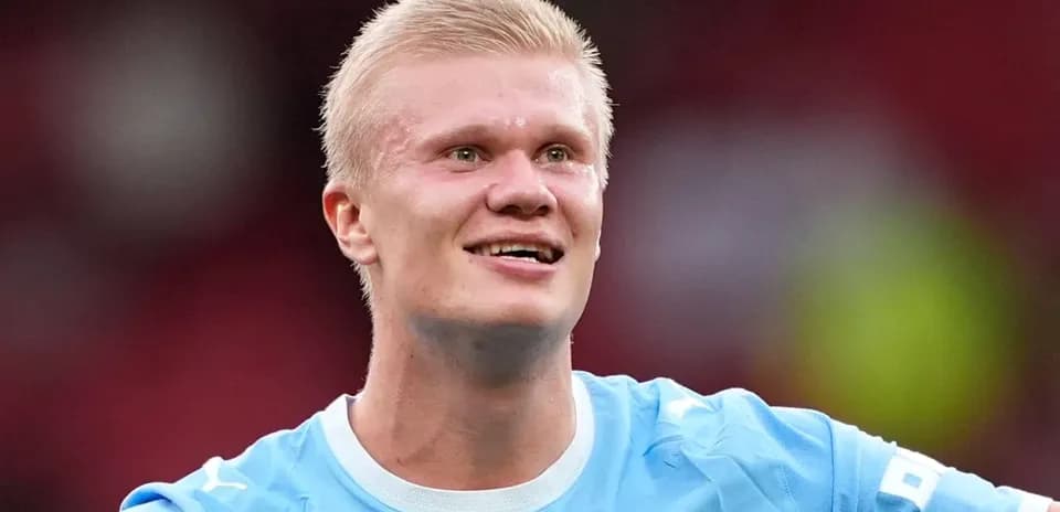 Jugador sonriente en camiseta azul durante partido