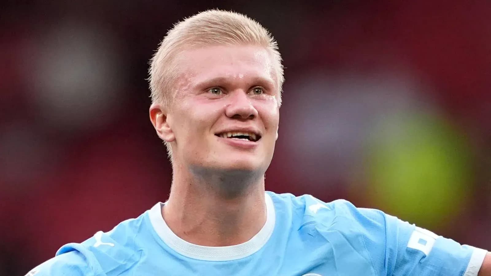 Jugador sonriente en camiseta azul durante partido