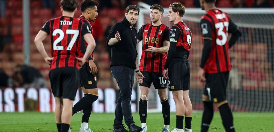 Entrenador hablando con jugadores del Bournemouth en campo