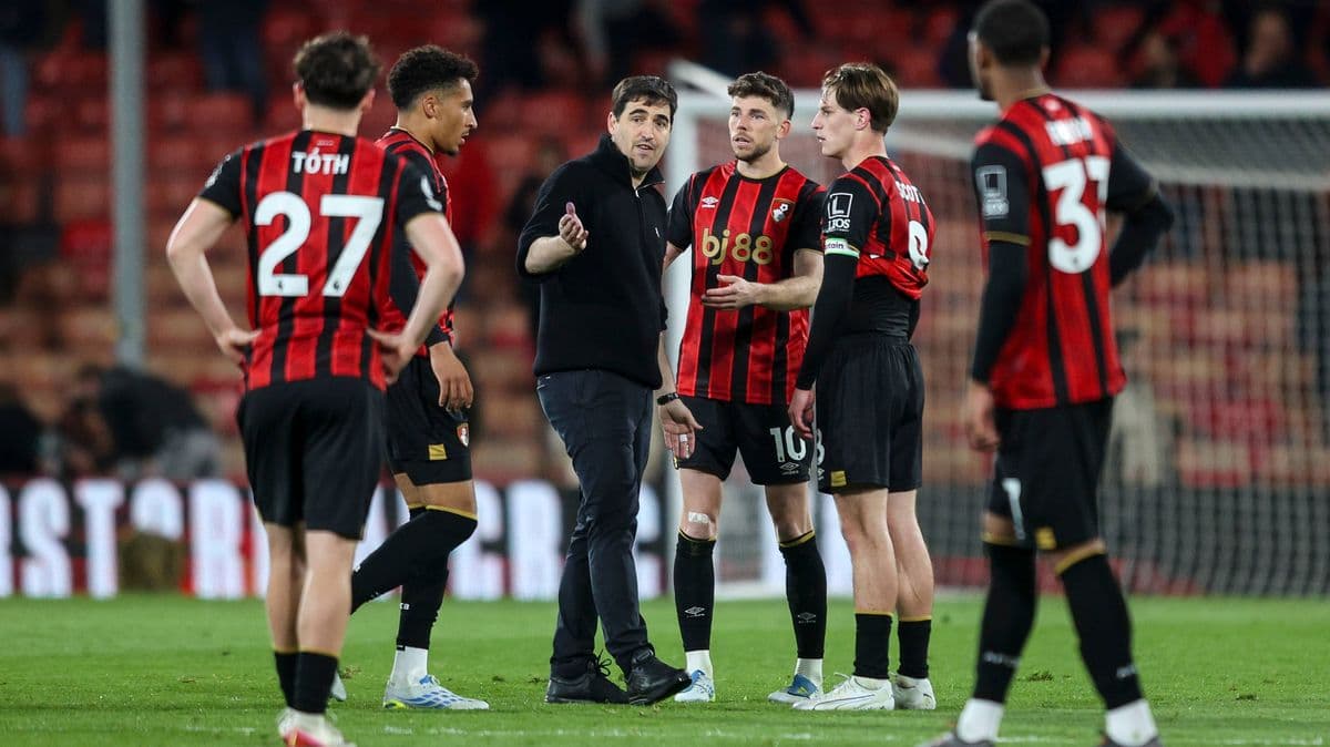 Entrenador hablando con jugadores del Bournemouth en campo