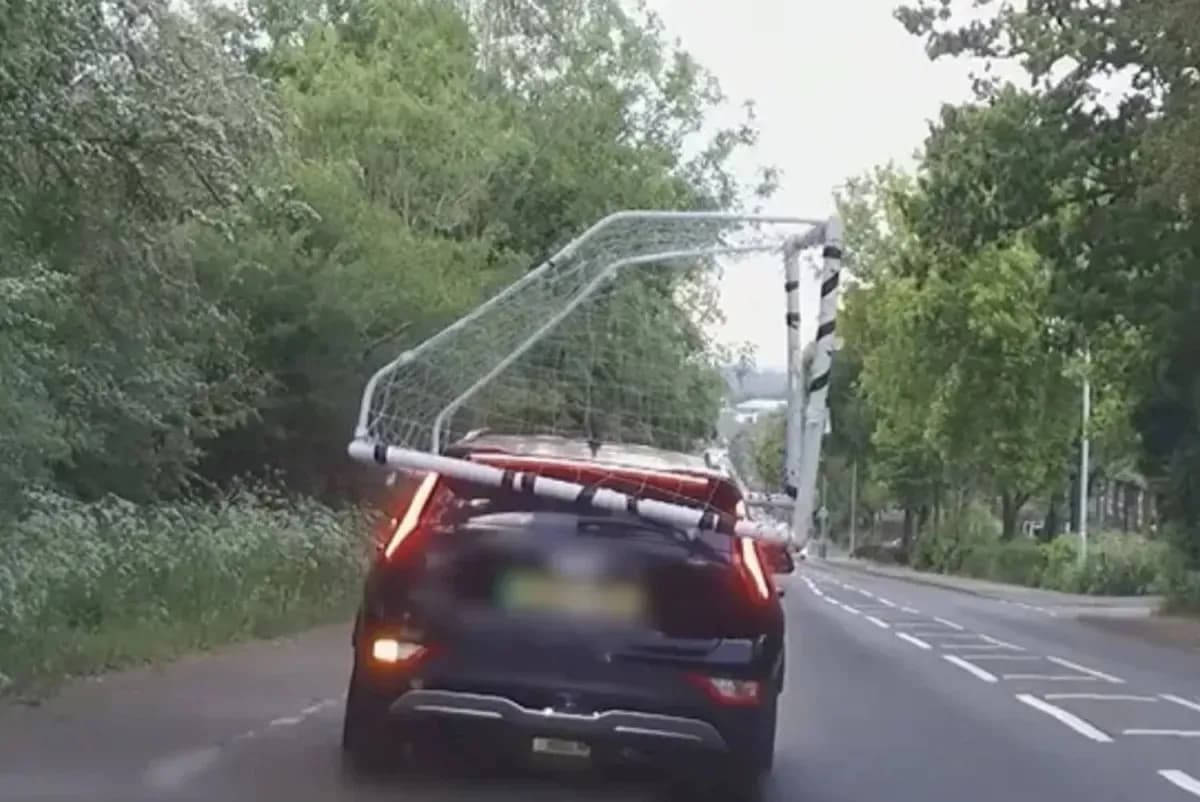 Coche transportando una portería de fútbol en carretera