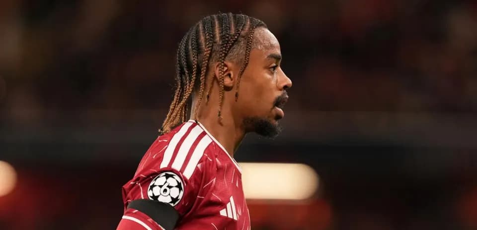 Jugador con camiseta roja y banda de capitán en el campo