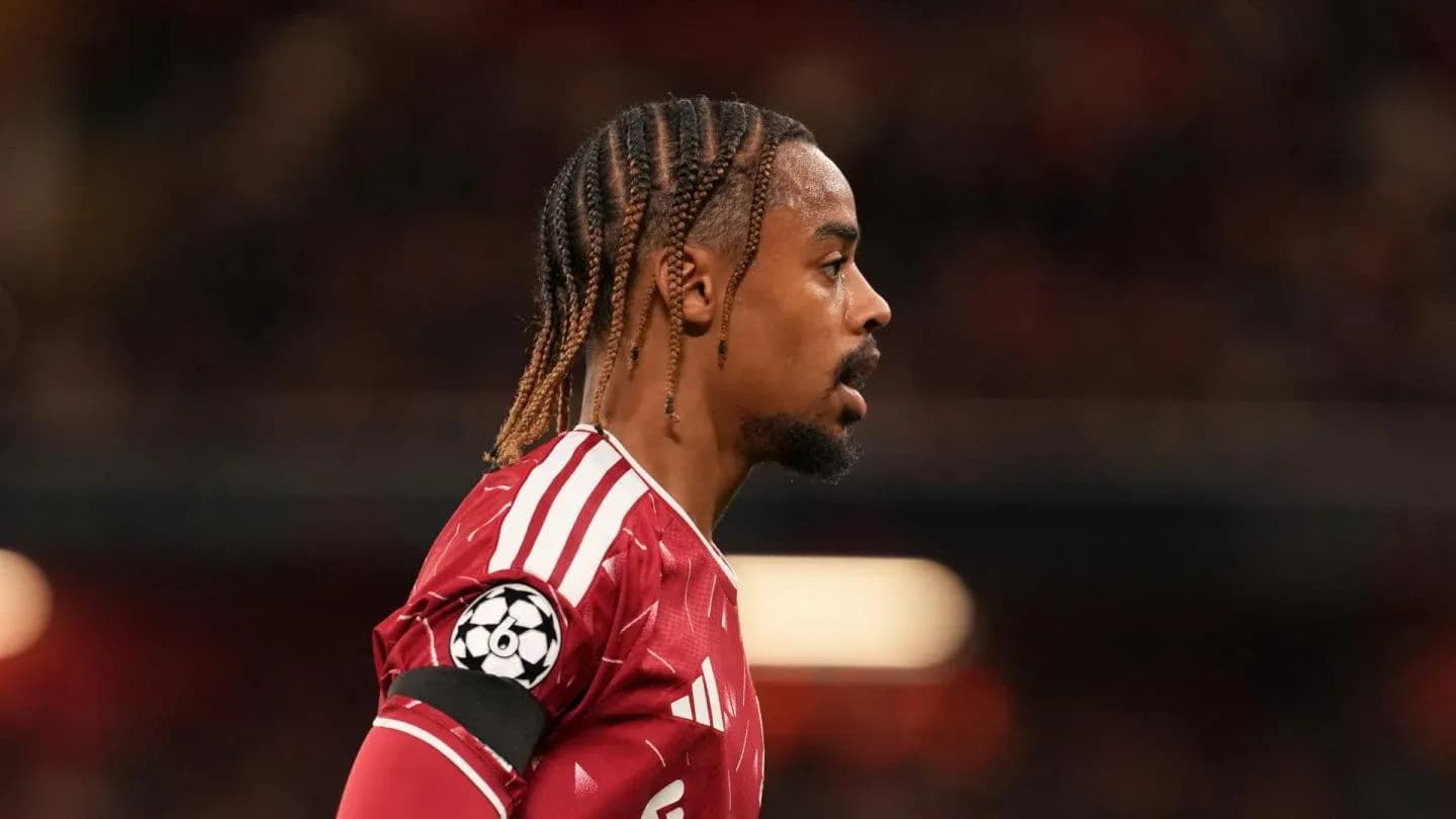 Jugador con camiseta roja y banda de capitán en el campo