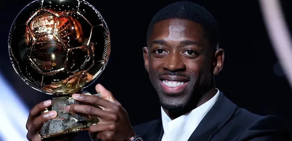Jugador sosteniendo el Balón de Oro con una sonrisa