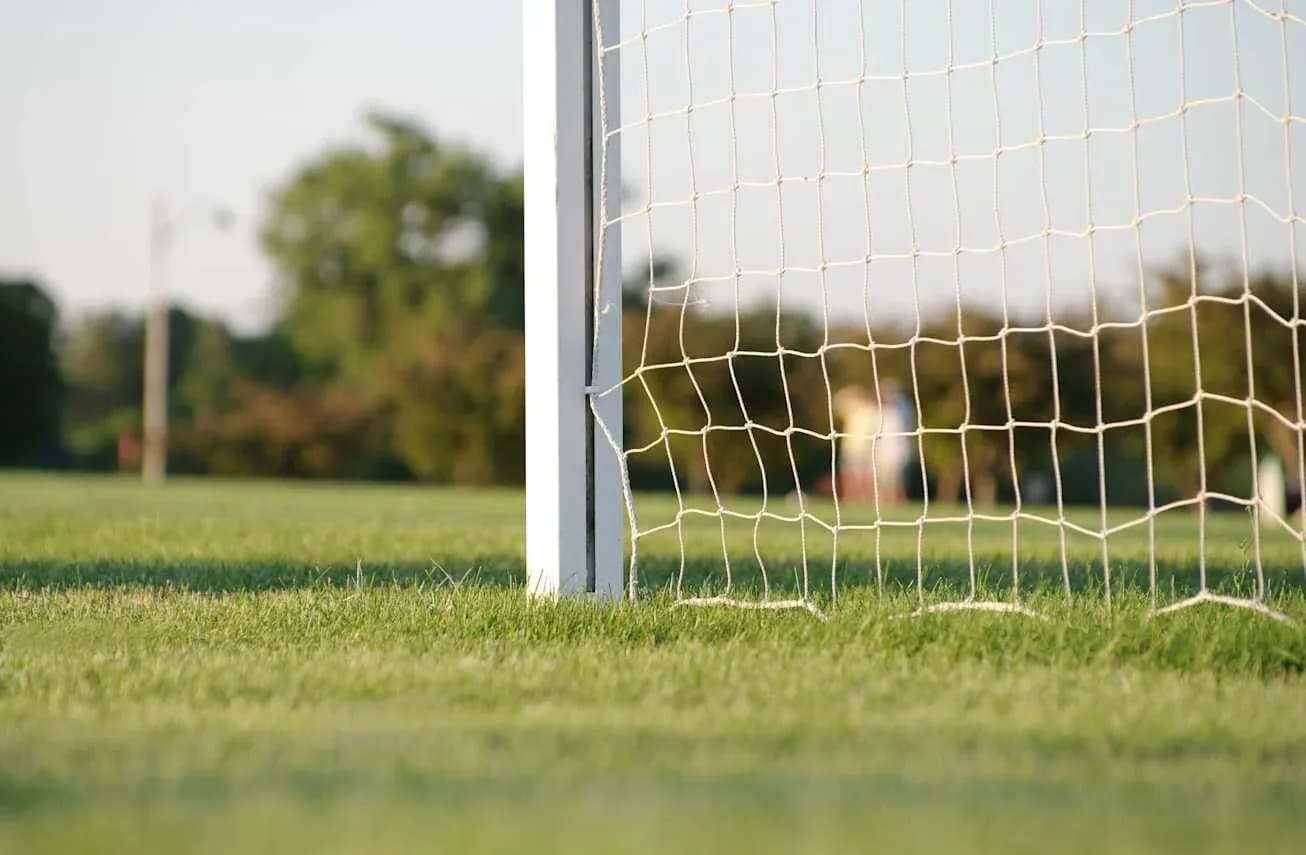 Poste de gol con red en campo de fútbol