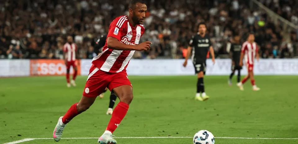 Jugador de Olympiacos corriendo tras el balón en campo