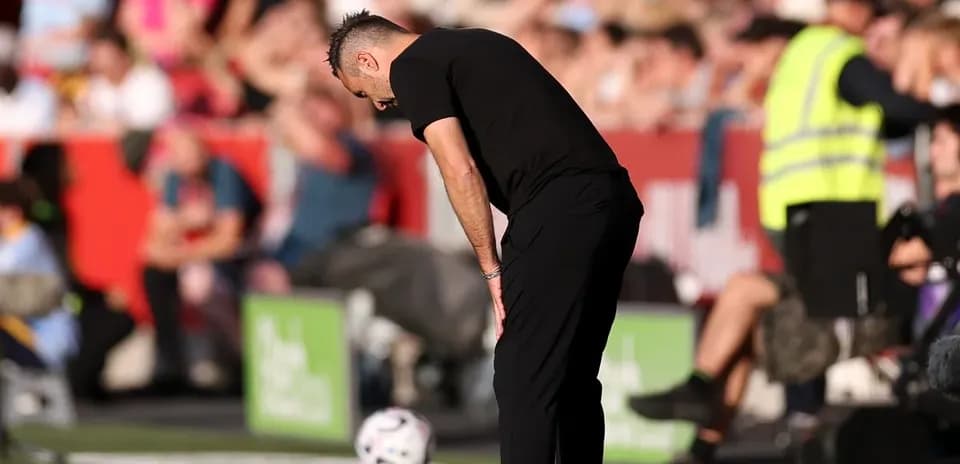 Entrenador mirando al suelo durante el partido