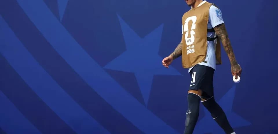 Jugador caminando con chaleco de calentamiento antes del partido