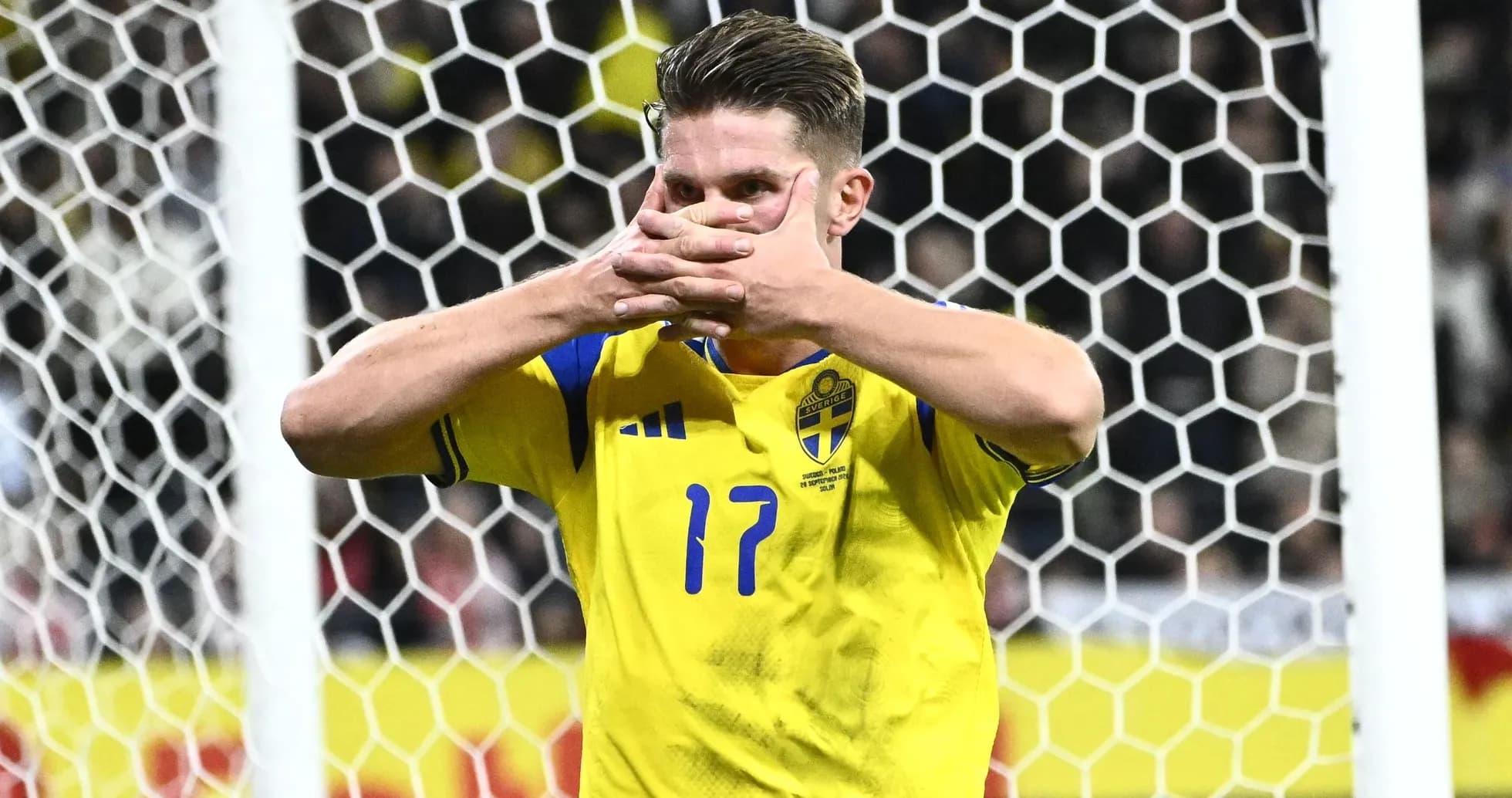 Jugador de Suecia señalando su camiseta en el campo
