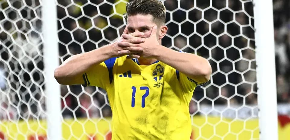 Jugador de Suecia señalando su camiseta en el campo