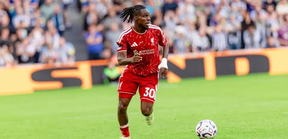 Jugador de Liverpool corriendo con el balón en el campo