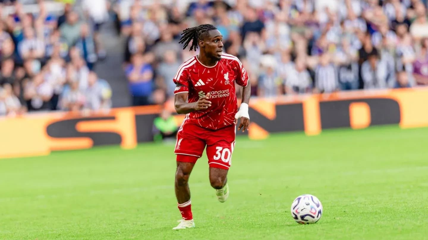 Jugador de Liverpool corriendo con el balón en el campo