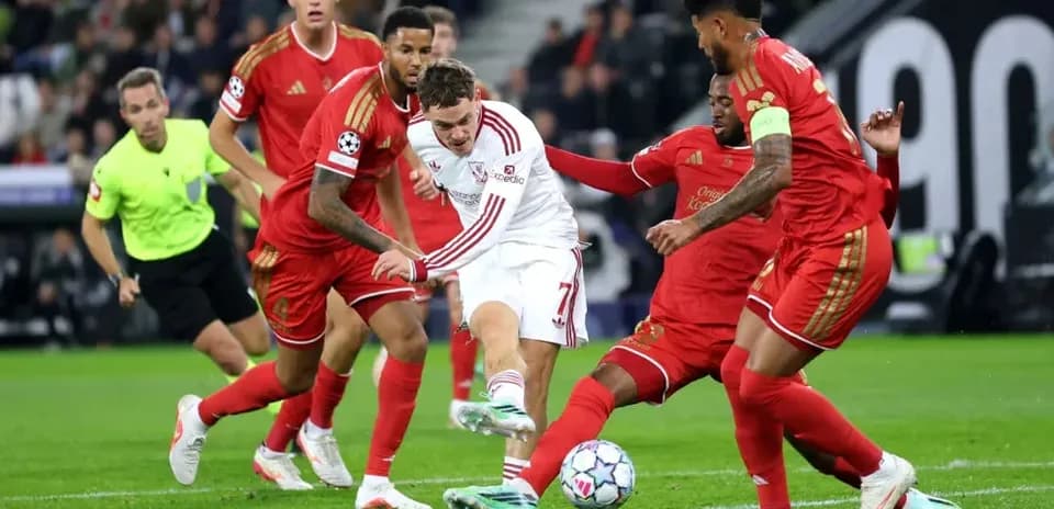 Jugador intentando driblar entre defensores durante partido