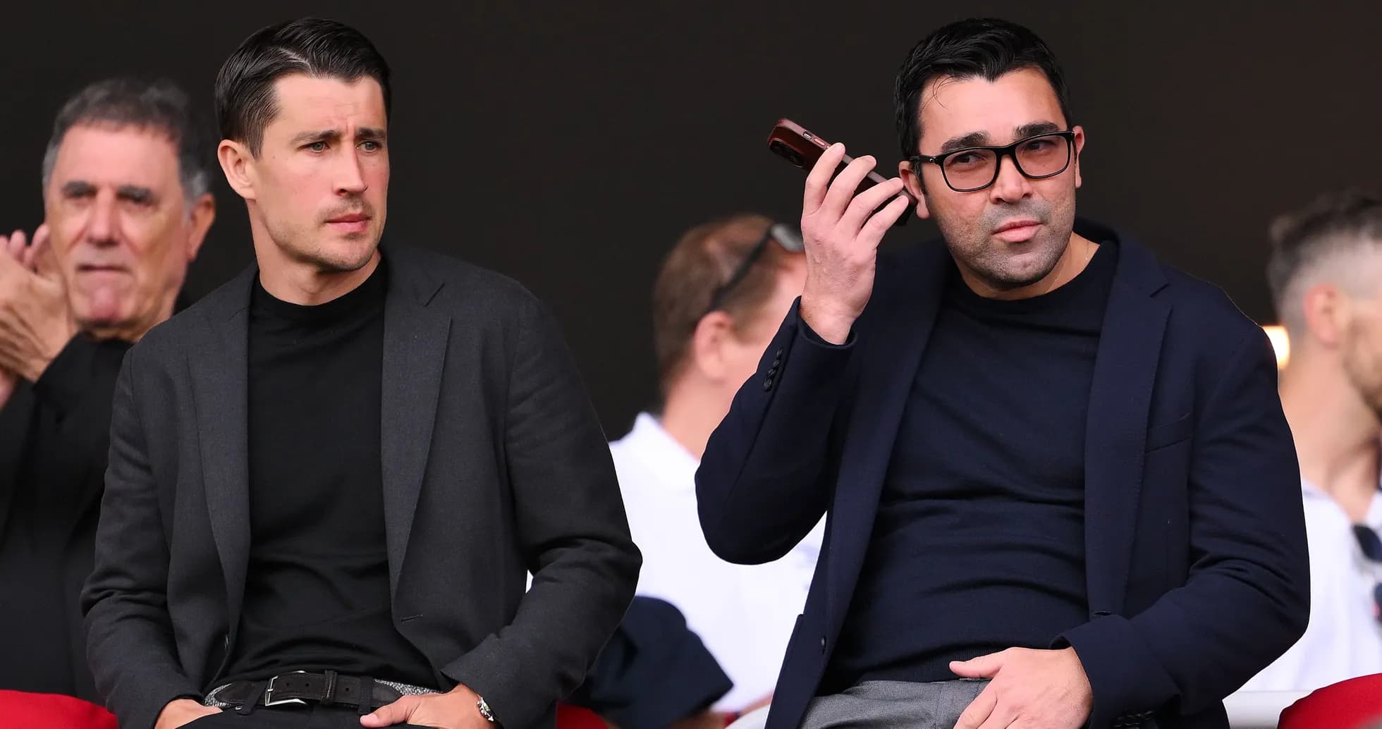 Dos hombres en la tribuna durante un evento deportivo