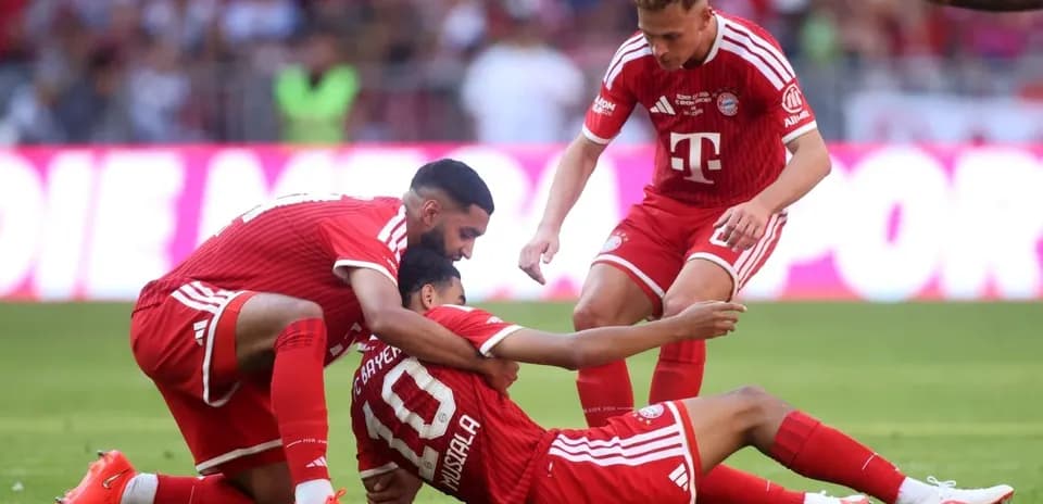Jugadores de Bayern Múnich ayudando a un compañero caído
