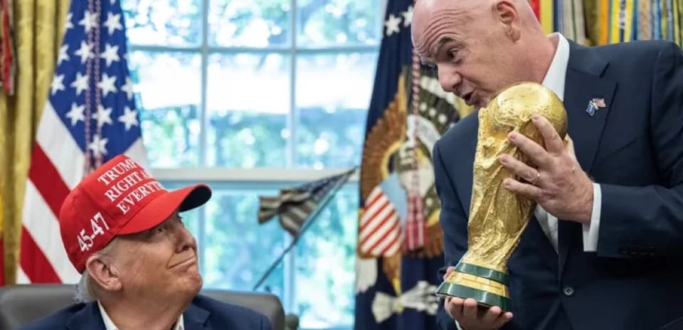 Hombre sosteniendo trofeo en sala con banderas