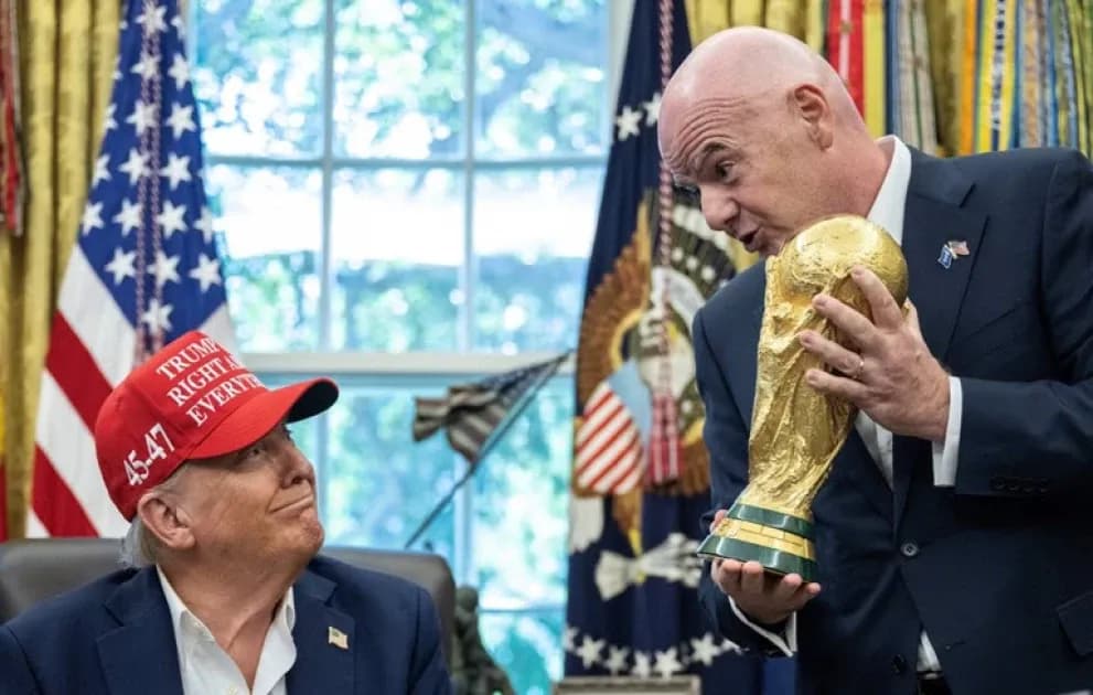 Hombre sosteniendo trofeo en sala con banderas