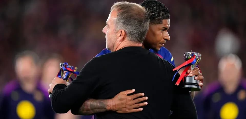 Entrenador y jugador abrazándose con trofeos