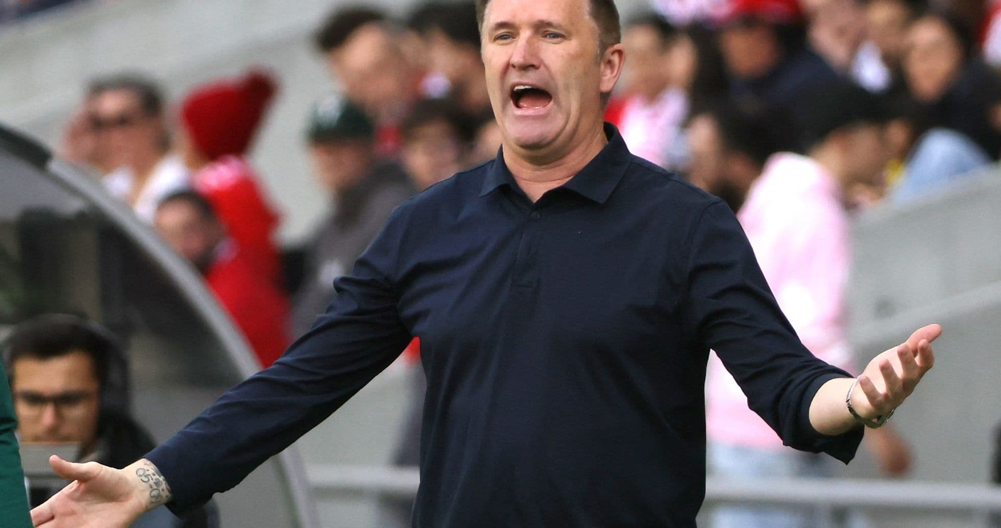 Entrenador gesticulando durante el partido en el banquillo