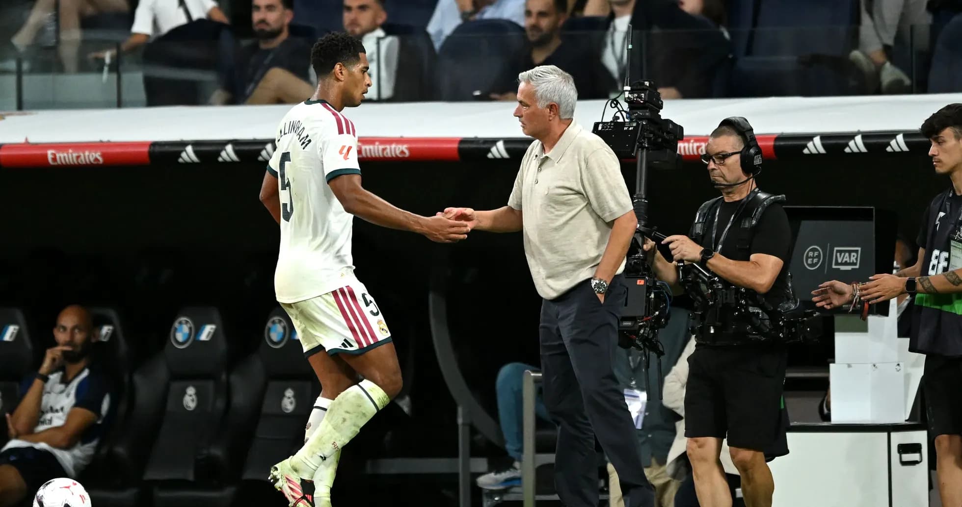 Jugador saludando al entrenador en la banda