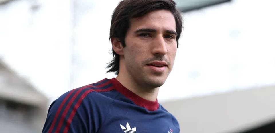 Jugador posando con camiseta de entrenamiento en estadio