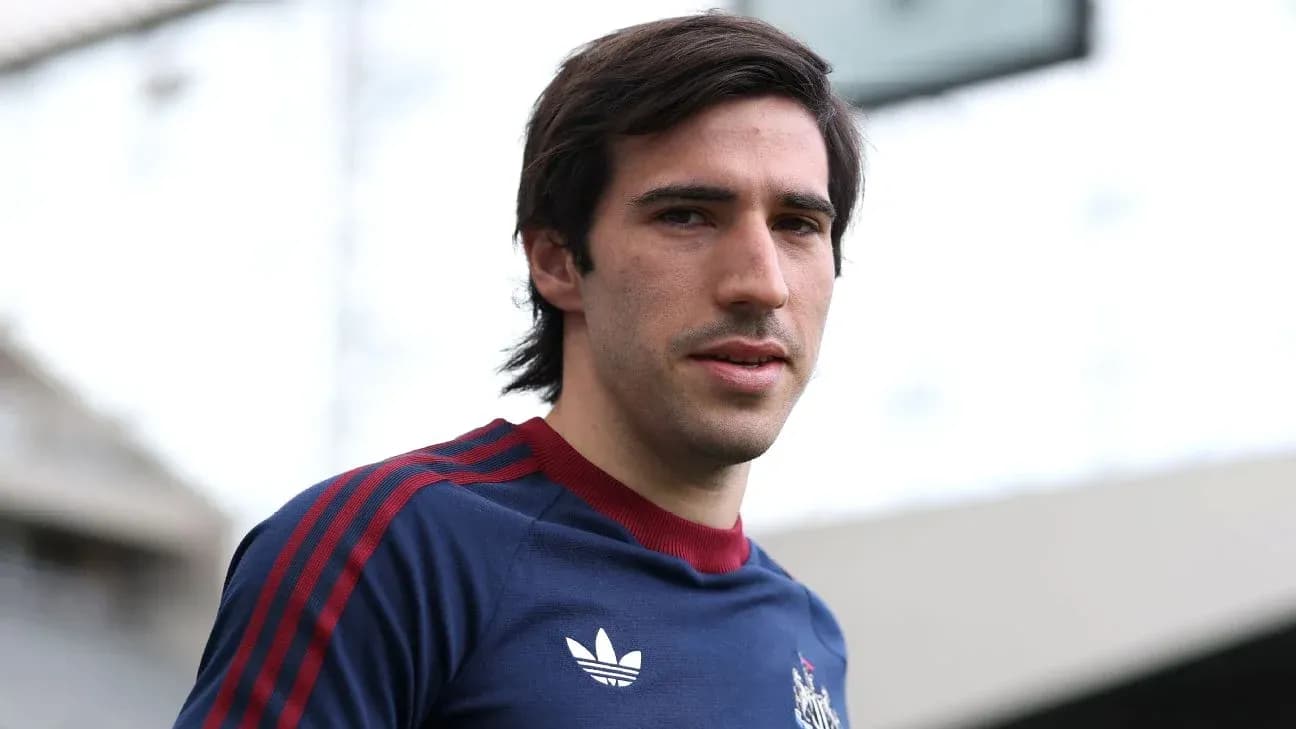 Jugador posando con camiseta de entrenamiento en estadio