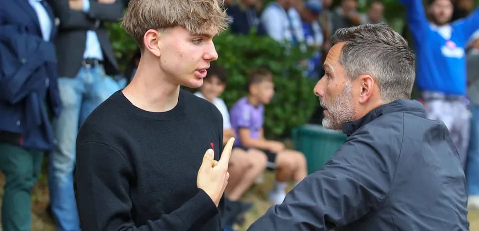 Dos hombres conversando en un evento deportivo