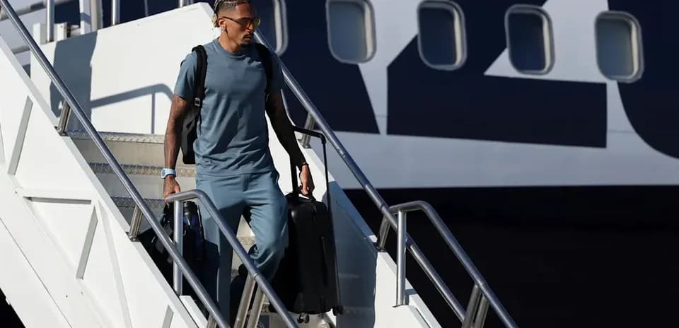 Jugador saliendo del avión con maleta