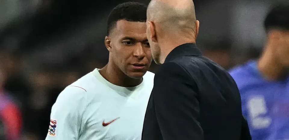 Kylian Mbappé conversando con entrenador en partido